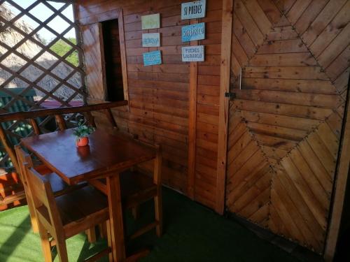 een kleine kamer met een tafel en een houten muur bij Posada chikiluky beach in Playa Blanca
