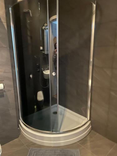 uma cabina de duche em vidro na casa de banho com um lavatório em Hostel Węgierki em Węgierki