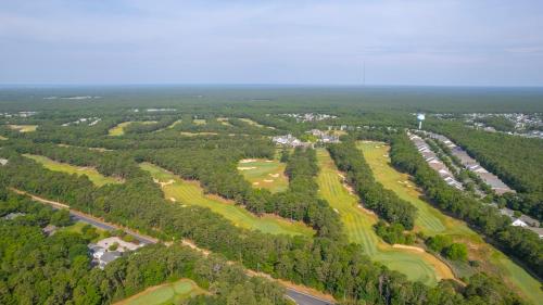 an aerial view of a golf course with trees at The Inn at LBI National Golf & Resort in Little Egg Harbor Township