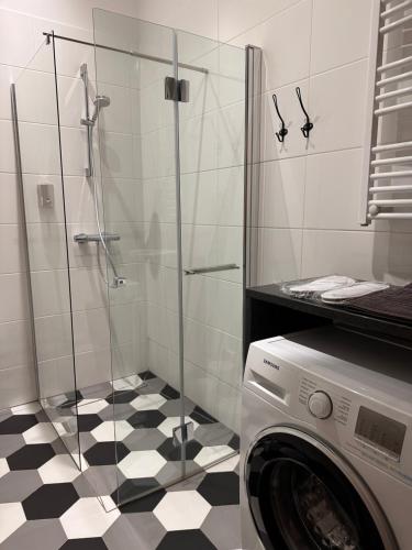 a bathroom with a shower and a washing machine at Centrum Apartamenty Stare Miasto in Kraków