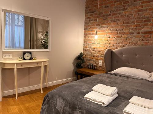 a bedroom with a bed and a brick wall at Centrum Apartamenty Stare Miasto in Kraków