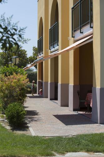 a person standing on a sidewalk next to a building at Residence Borgomare in Albenga
