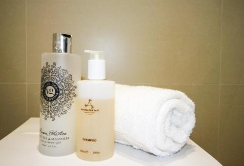 una bottiglia di shampoo e un asciugamano sul bancone del bagno di Modern Studio for LONG STAY BUSINESS & RELOCATIONS a Hemel Hempstead
