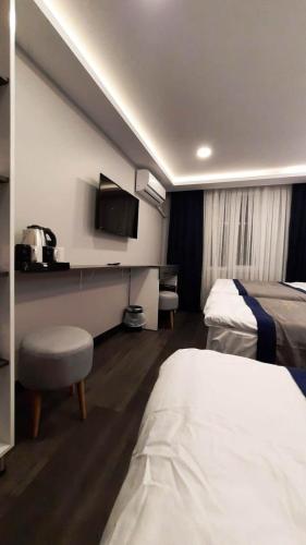 a hotel room with two beds and a tv at SAND DOOR HOTEL in Istanbul