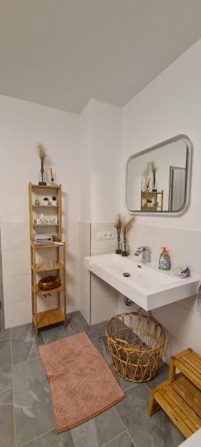 a white bathroom with a sink and a mirror at Gästewohnung My Secret Garden 