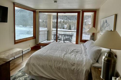 a bedroom with a bed and a balcony at Keystone Lakeside Condo in Keystone