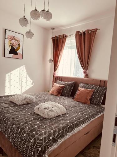 a bedroom with a bed with pillows and a window at Apartman Jovičić in Bjelovar