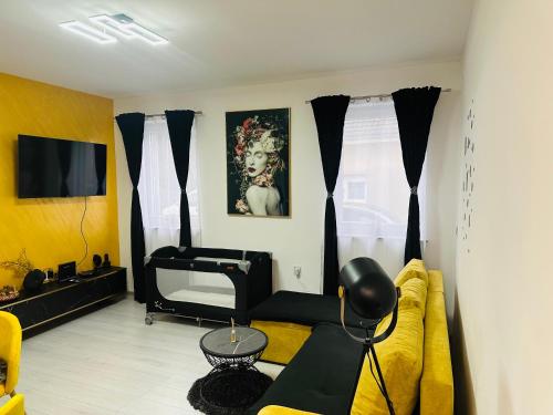 a living room with a yellow couch and a television at Apartman Jovičić in Bjelovar