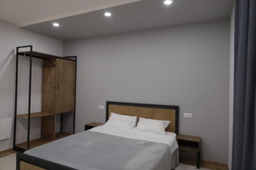 - une chambre avec un lit et une tête de lit en bois dans l'établissement Modern House 2, à Dilidjan