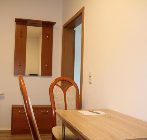a dining room table with two chairs and a mirror at Pension963 in Crimmitschau