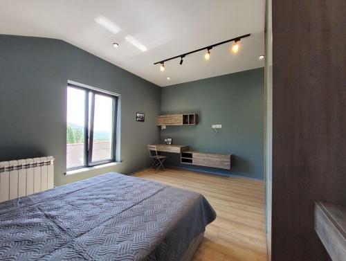 a bedroom with a bed and a desk and a window at Lady and Bear GH in Sǝrdakhar