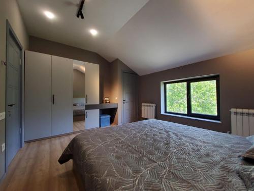 a bedroom with a large bed and a window at Lady and Bear GH in Sǝrdakhar