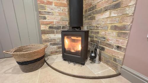 a wood burning stove in a brick wall at Rural Retreat, Wood Burner, Patio, Lawn, Breakfast, new wifi in Warminster