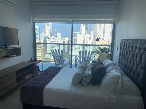 a bedroom with a bed with a view of a city at Acogedor y lujoso apartamento en edificio infinitum in Cartagena de Indias