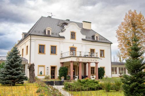 a large white house with a black roof at Pałac na Wodzie Hotel & SPA in Jelenia Góra