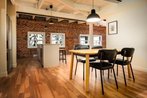 a dining room with a table and chairs and a brick wall at Les Lofts de la Barricade - Par les Lofts Vieux-Québec in Quebec City