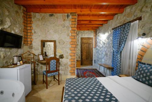 a bedroom with a bed and a desk in a room at Cappadocia Nar Cave House & Swimming Pool in Nevsehir