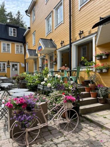 una bicicleta estacionada frente a un edificio con flores en Central lägenhet, en Norrtälje