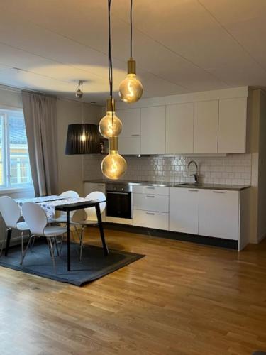 een keuken met een tafel en stoelen in een kamer bij Central lägenhet in Norrtälje