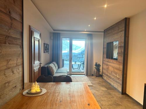 a room with a table and a living room with a couch at Apartments Oberkofler in Hollersbach im Pinzgau