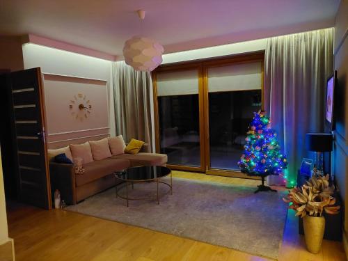 una sala de estar con un árbol de Navidad y un sofá en Nowoczesne domki z kominkami, sauną i fotelem masującym Bayamo, Lucca, Hawana I i Hawana II, en Święta Katarzyna