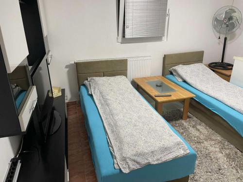a small room with two beds and a table at APRTMAN SARAJEVO ZA DVIJE OSOBE in Sarajevo