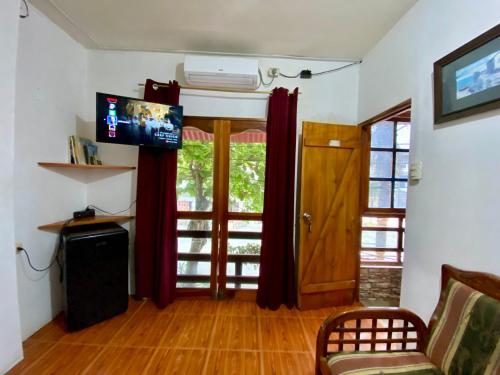 uma sala de estar com um sofá, uma televisão e uma porta em UFO House em Montañita