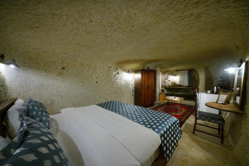 a bedroom with a bed and a chair in a room at Cappadocia Nar Cave House & Swimming Pool in Nevsehir