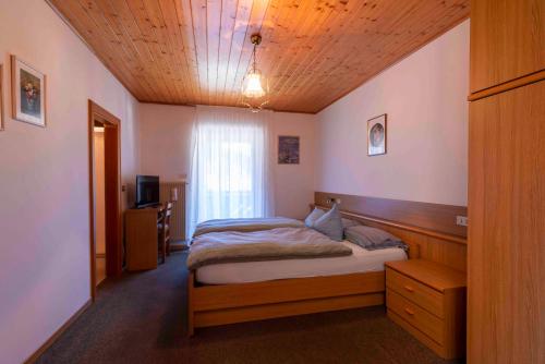 una camera con letto e soffitto in legno di Césa Col De Pin a Canazei