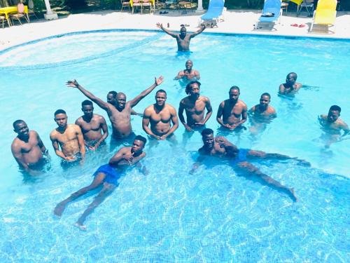 a group of men swimming in a swimming pool at odivin hotel luxury suite in Gonaïves