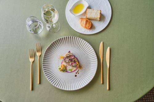 a table with two plates of food and forks and glasses at Harmonie Embrassee in Osaka