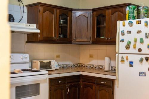 a kitchen with wooden cabinets and a white refrigerator at Residencia Sofmel in Copan Ruinas
