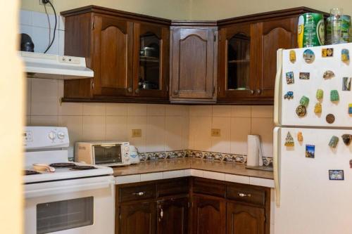 cocina con armarios de madera y nevera blanca en Residencia Sofmel, en Copan Ruinas