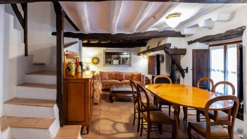 a dining room with a table and a couch at Casa rural la grande in Casas del Castañar