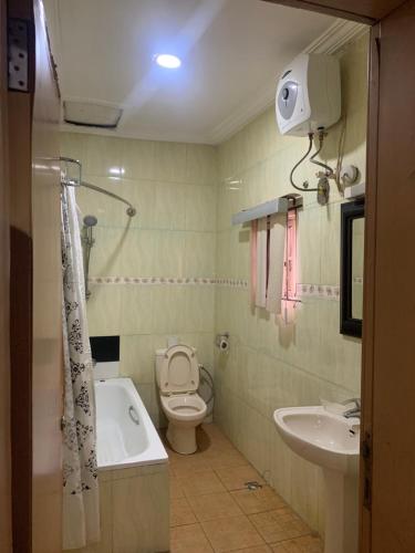 a bathroom with a tub and a toilet and a sink at Tivoli Residence & Hotels in Lagos