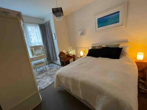 a bedroom with a large white bed and a desk at One/Two Bedroom Apartment Close to Sea & Centre in Hastings