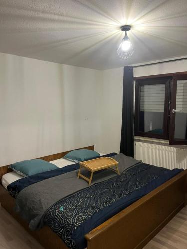 Un dormitorio con una cama grande y una mesa. en Appartement avec terrasse, en Kehl am Rhein