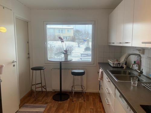 a kitchen with a sink and two stools in front of a window at Vivian house in Gothenburg