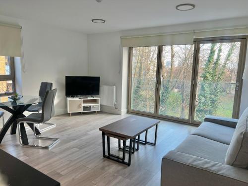 a living room with a couch and a table at Kensington House by Solitaire Suites in Slough