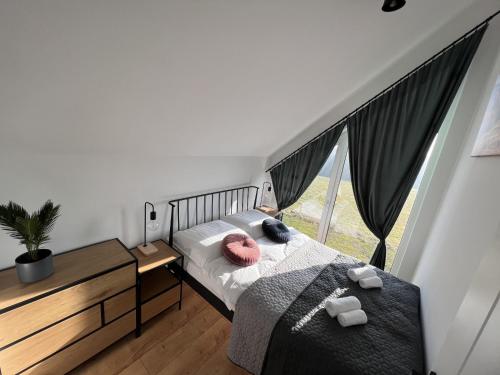 a bedroom with a bed and a large window at Górska Stodoła in Lipowa