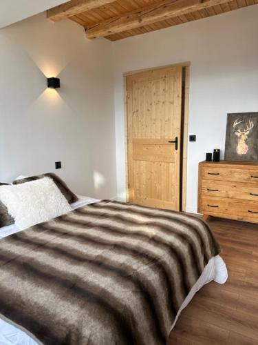 a bedroom with a bed and a wooden door at Les 100 Ciels Font-Romeu in Font Romeu Odeillo Via