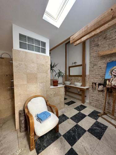a bathroom with a sink and a chair in a room at Garsoniera 2 lângă plaja in Constanţa