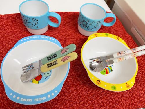 a toy train on a plate next to two cups at HimawariRyokanひまわり旅館 in Okayama