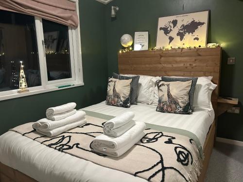 a bedroom with a bed with four towels on it at Woodpecker Lodge in Newquay