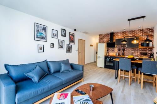 un salon avec un canapé bleu et une cuisine dans l'établissement le loft, à Marseille