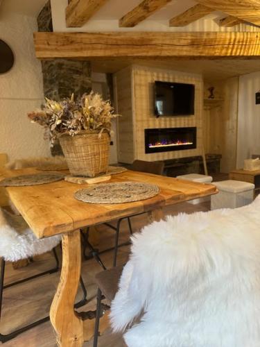 a living room with a wooden table with a fireplace at Les 100 Ciels Font-Romeu in Font Romeu Odeillo Via