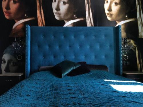 ein blaues Bett mit einem blauen Kopfteil mit zwei Frauen in der Unterkunft City Center by Better Place in Warschau