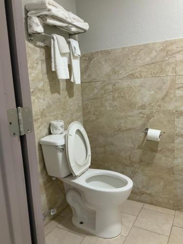 a bathroom with a toilet and towels on a wall at Value Lodge in Alpine