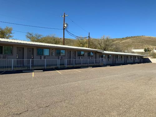 a building with a fence in a parking lot at Value Lodge in Alpine
