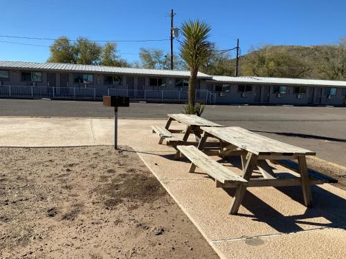 two wooden picnic tables in front of a building at Value Lodge in Alpine
